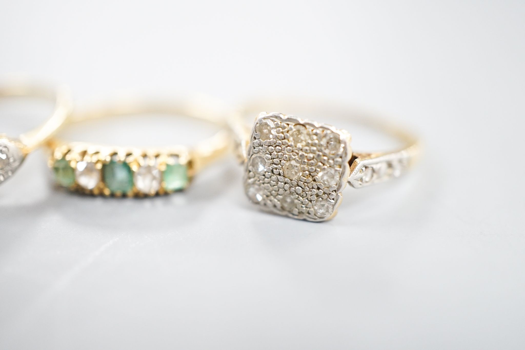 Two 18ct, plat. and diamond chip set dress rings and an 18ct, emerald and diamond set five stone ring, sizes P,I and H/I, gross weight 6 grams.